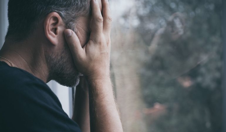 man holding head face sad rain