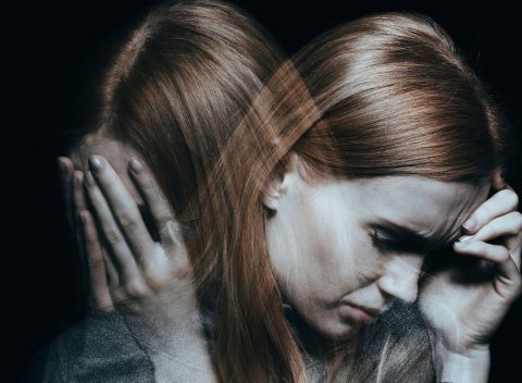 woman holding head upset