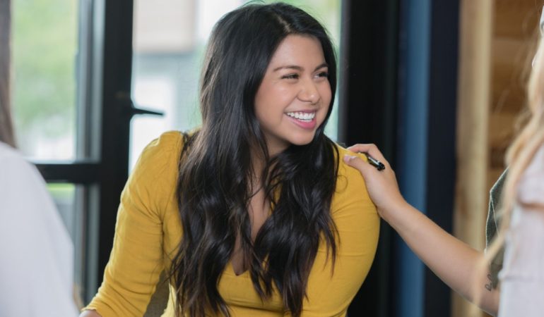 woman smile smiling hand on shoulder yellow shirt