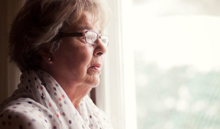 old woman looking out window