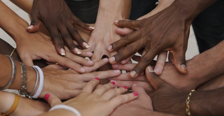 Many hands together: group of people joining hands