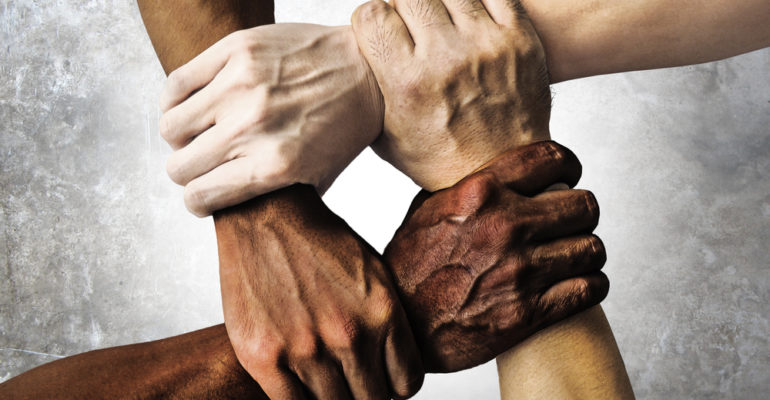 multiracial group with black african American Caucasian and Asian hands holding each other wrist in tolerance unity love and anti racism concept