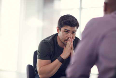 What do I do. an unhappy young man talking with a colleague.