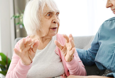 Old Grandma Chats With Granddaughter On Hallway Couch