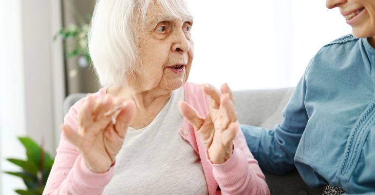 Old Grandma Chats With Granddaughter On Hallway Couch