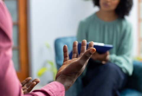 Midsection of african american male patient attending therapy with biracial female therapist. Mental health, therapy and counselling.