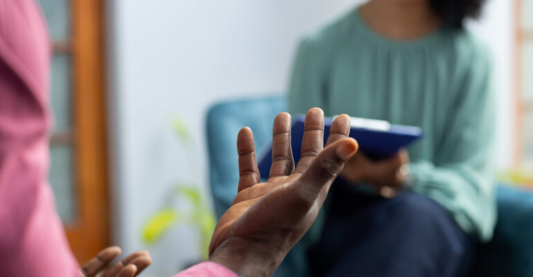 Midsection of african american male patient attending therapy with biracial female therapist. Mental health, therapy and counselling.