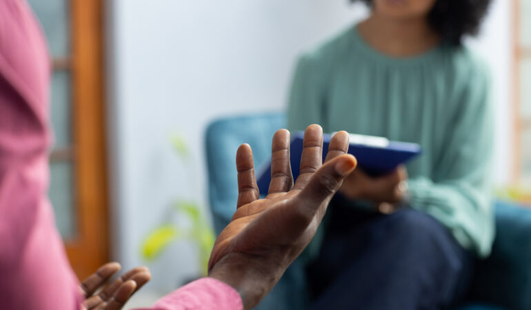 Midsection of african american male patient attending therapy with biracial female therapist. Mental health, therapy and counselling.