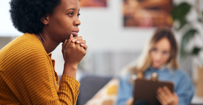 Mental health, anxiety and psychology with a black woman in therapy, talking to a professional. Depression, stress or support with a young patient in session with a psychologist for grief counseling