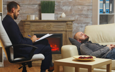 Bearded man laying down on couch at couple therapy