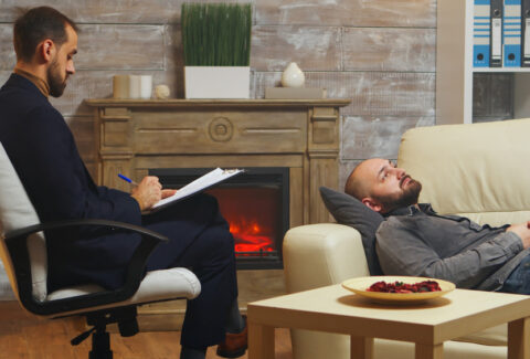 Bearded man laying down on couch at couple therapy