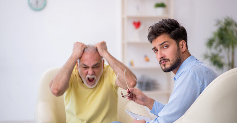 Old man visiting young male psychotherapist