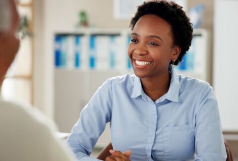 Black woman, employee and happy with senior customer at office for retirement and pension plans as financial advisor. Female person, people and smile with client as for will consultation service