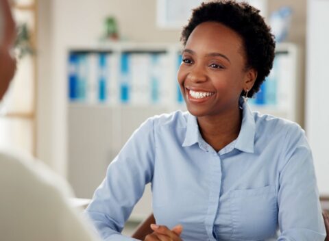 Black woman, employee and happy with senior customer at office for retirement and pension plans as financial advisor. Female person, people and smile with client as for will consultation service