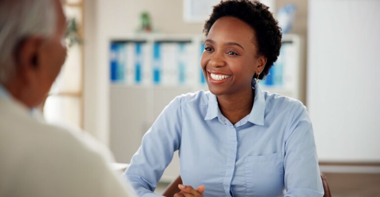 Black woman, employee and happy with senior customer at office for retirement and pension plans as financial advisor. Female person, people and smile with client as for will consultation service