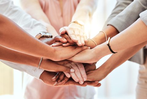 Teamwork, community and support with hands of business people together for collaboration, networking and goals. Mission, team building and motivation with employees for vision, diversity and growth