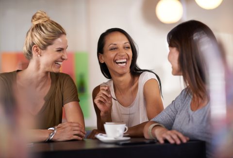 Once she got them laughing they couldnt stop. three women enjoying a conversation in a restaurant.